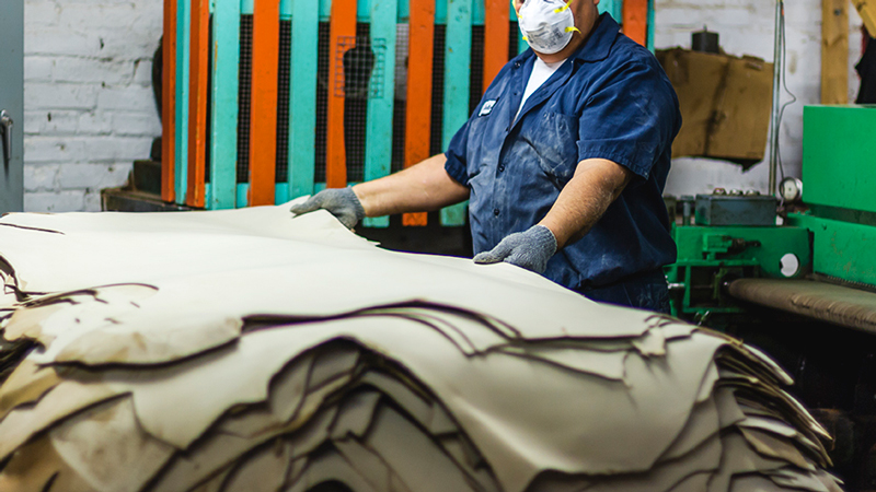 Horween employee stacking leather