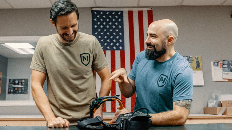 Two men laughing in front of an USA flag