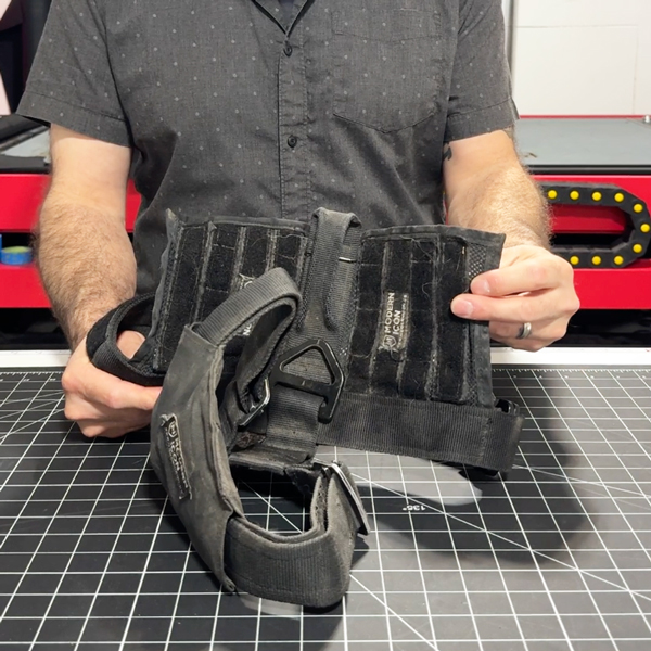 Older Patrol Harness with visible wear and tear, white fur embedded into fabric, and sharp right-angle corners on the padding.